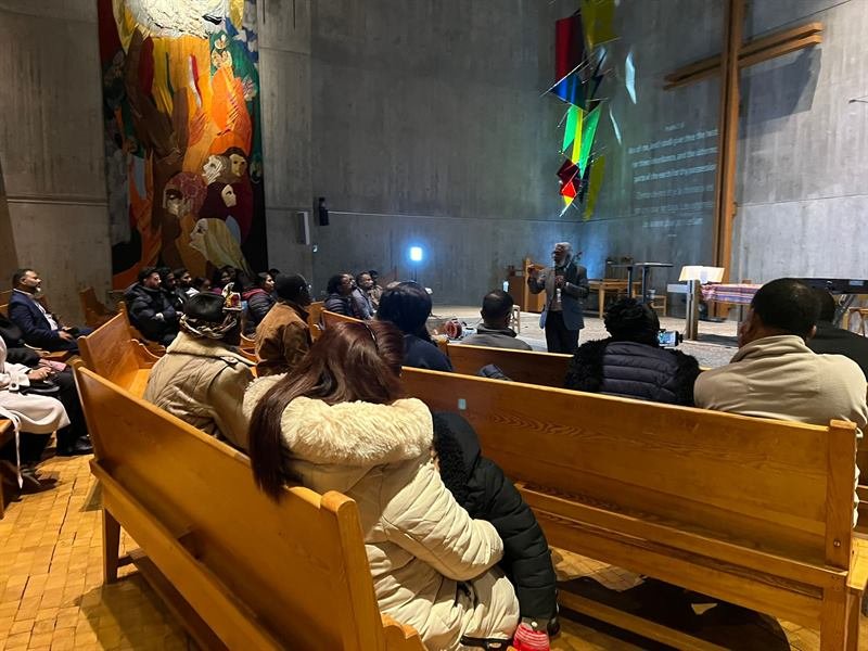 Evangelist Norman J. Sinappen preaching to the congregation seated in the sanctuary