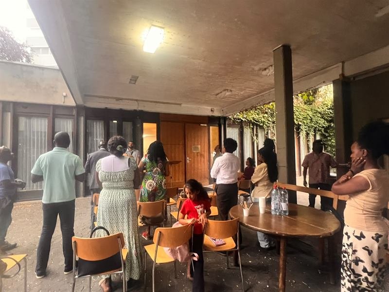The church standing together in prayer in the courtyard