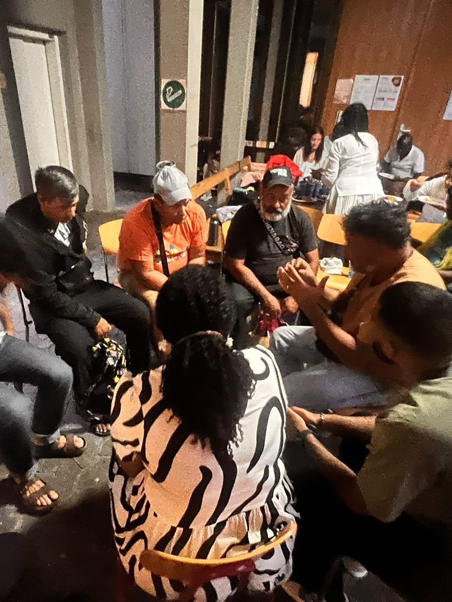 Members of the church sitting together in the courtyard after a gathering
