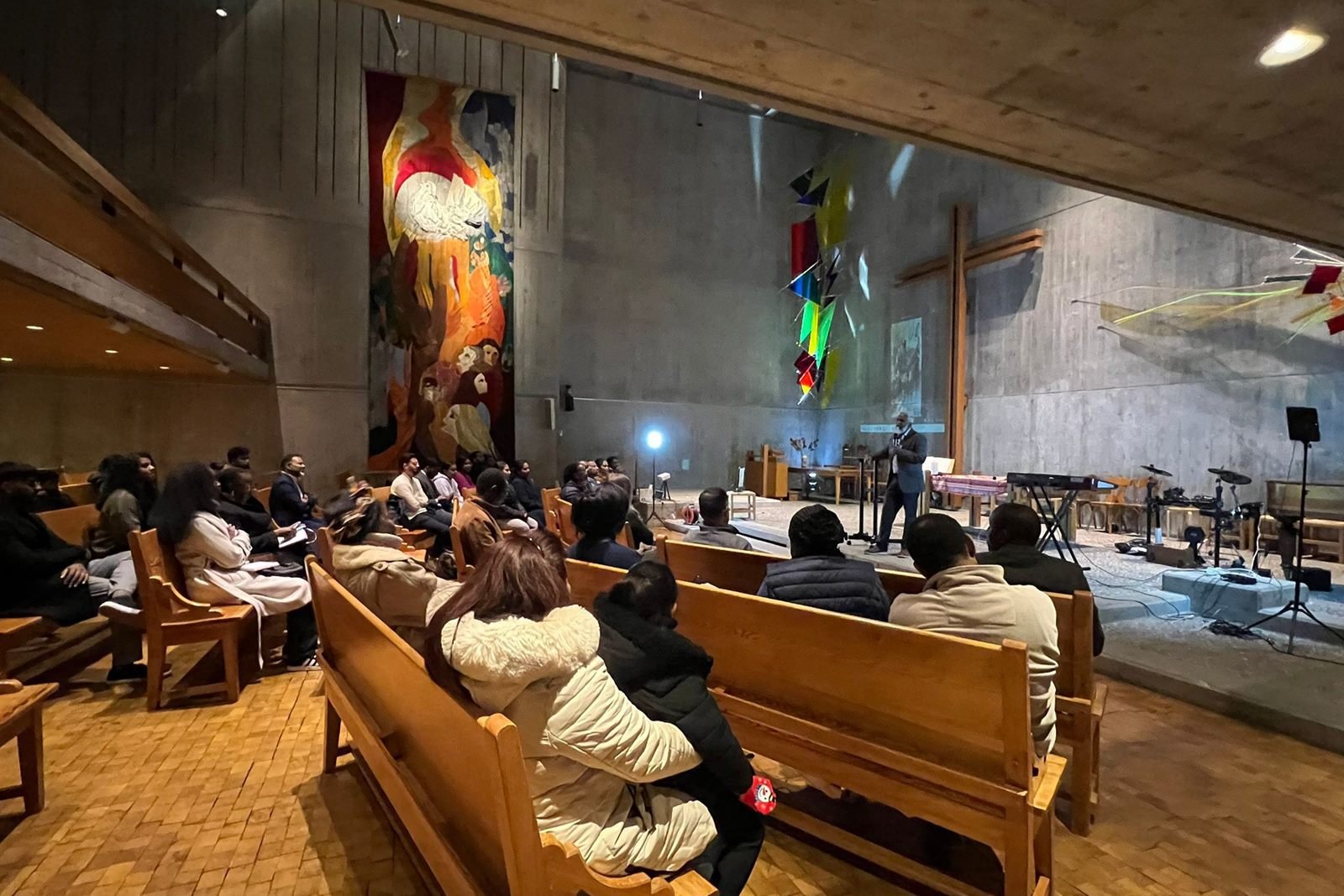 A wide view of the sanctuary during a gathering, with the band playing and the congregation in the pews